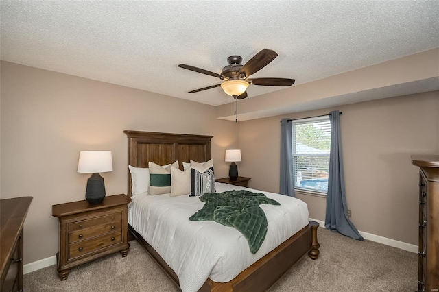 bedroom with baseboards, a ceiling fan, a textured ceiling, and light colored carpet