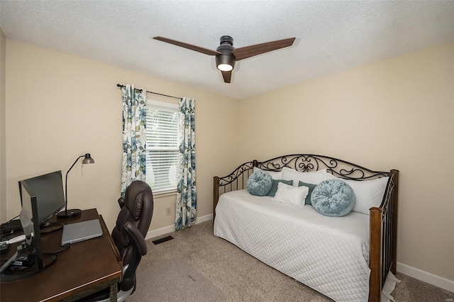 carpeted bedroom with a textured ceiling, ceiling fan, visible vents, and baseboards