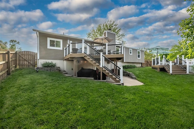 back of property with a deck, stairs, and a fenced backyard