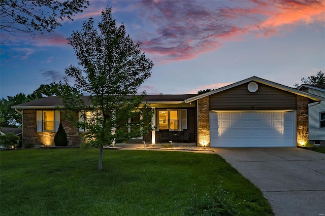 single story home featuring a garage, concrete driveway, a front lawn, and brick siding