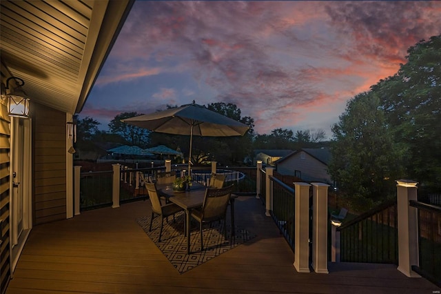 deck at dusk featuring outdoor dining area