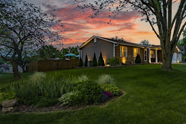 view of side of property with a lawn and fence