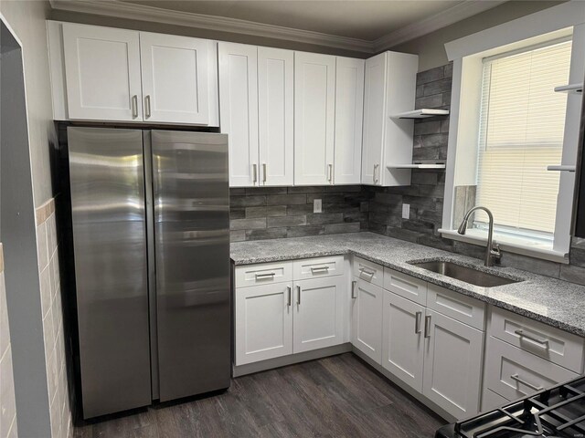 kitchen with freestanding refrigerator, white cabinetry, open shelves, and a sink