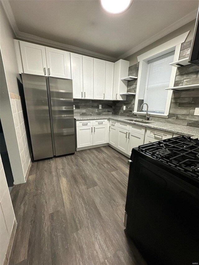 kitchen with crown molding, freestanding refrigerator, a sink, and black range with gas cooktop