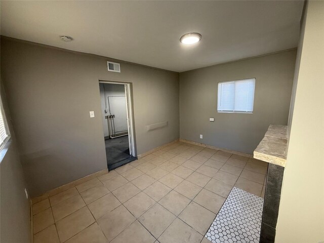 empty room featuring visible vents and light tile patterned floors