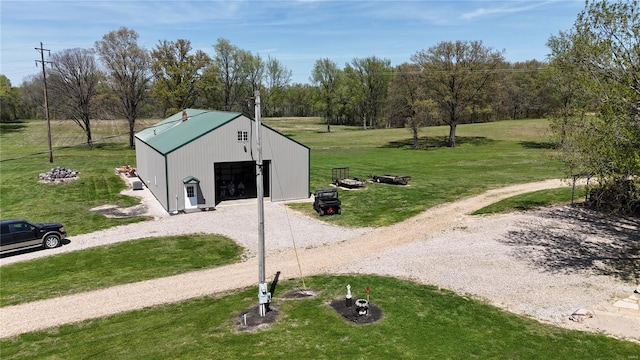 surrounding community with an outdoor structure, dirt driveway, a pole building, a yard, and a detached garage