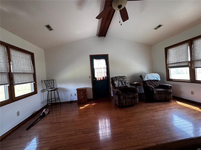 sitting room with a ceiling fan, visible vents, lofted ceiling with beams, and hardwood / wood-style floors