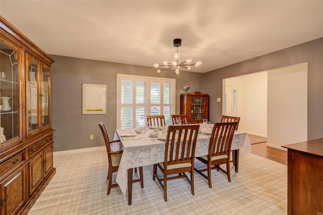 dining area featuring baseboards and a notable chandelier