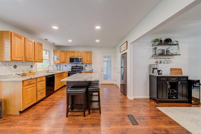 kitchen featuring a sink, black appliances, dark wood-type flooring, recessed lighting, and decorative backsplash