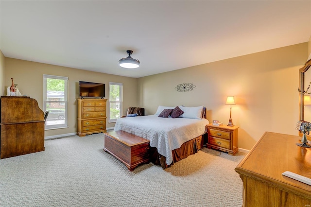 bedroom with light colored carpet and baseboards