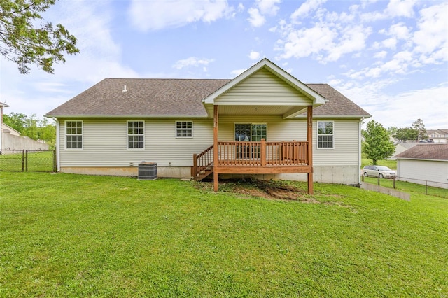 rear view of house with a yard, cooling unit, a shingled roof, and a deck
