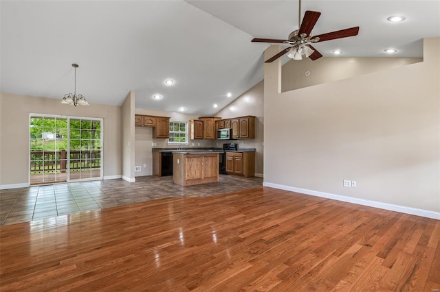 unfurnished living room featuring recessed lighting, baseboards, ceiling fan with notable chandelier, high vaulted ceiling, and wood finished floors