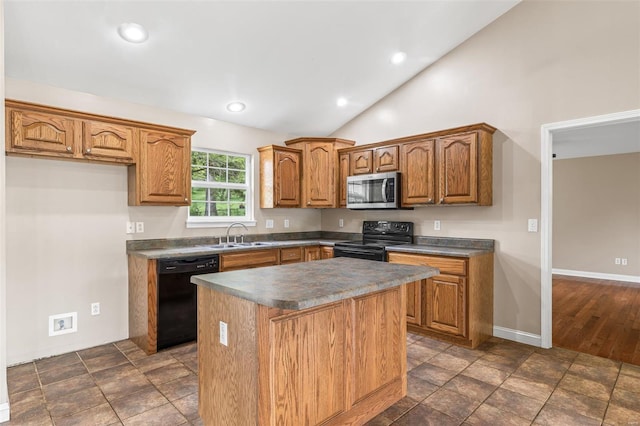 kitchen featuring black appliances, dark countertops, brown cabinets, and a center island
