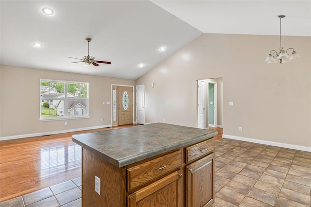 kitchen featuring vaulted ceiling, ceiling fan with notable chandelier, open floor plan, and dark countertops