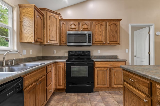 kitchen featuring brown cabinets, black appliances, and a sink