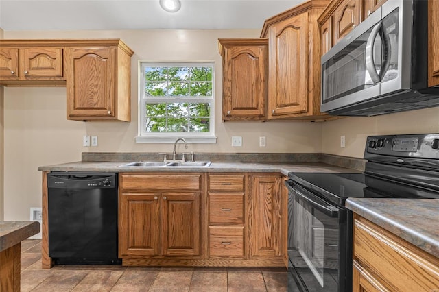 kitchen with a sink, black appliances, and brown cabinets