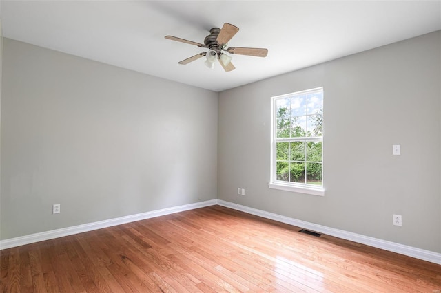 unfurnished room featuring baseboards, visible vents, light wood-type flooring, and a ceiling fan