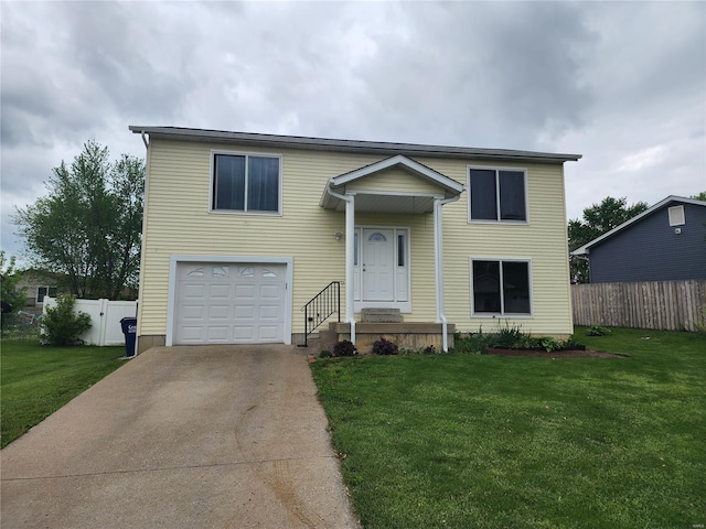 split foyer home featuring concrete driveway, an attached garage, fence, and a front yard
