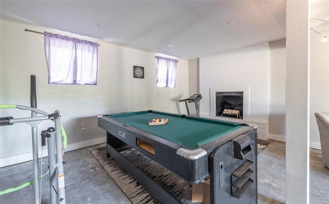 game room featuring a high end fireplace, billiards, and unfinished concrete floors