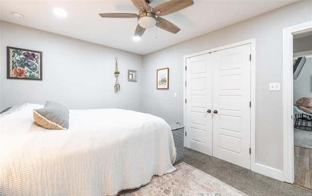 bedroom with baseboards, ceiling fan, a closet, and carpet flooring