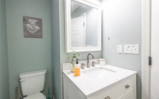 half bathroom with vanity and toilet