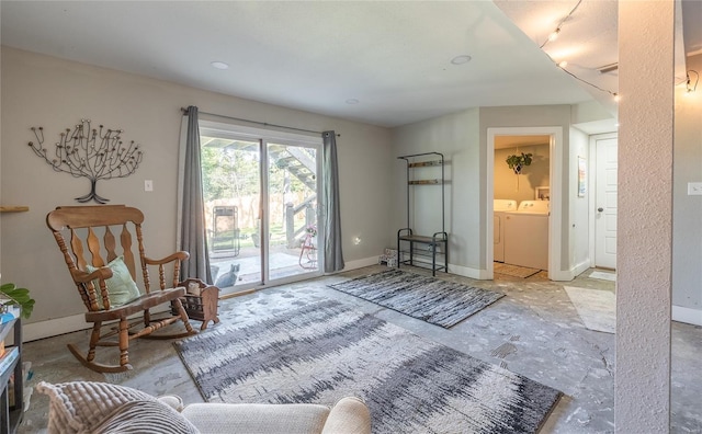 living area with washing machine and clothes dryer and baseboards
