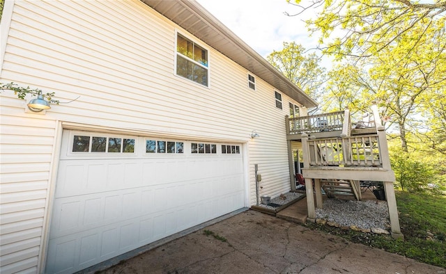 view of home's exterior with a wooden deck, an attached garage, and driveway