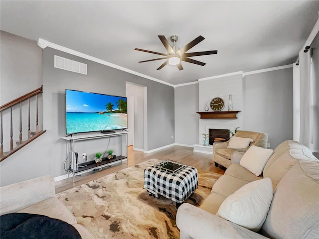 living area featuring ceiling fan, visible vents, wood finished floors, stairway, and baseboards