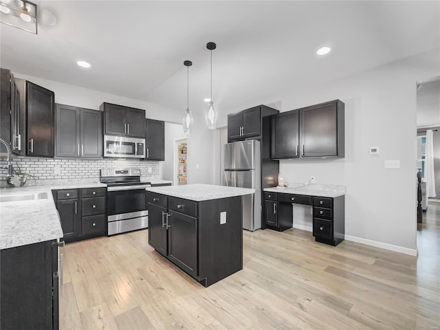 kitchen featuring light wood-style floors, light countertops, a sink, backsplash, and stainless steel appliances