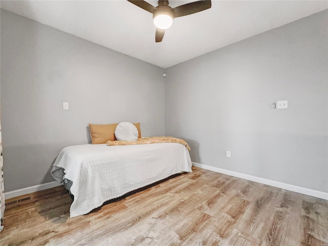 bedroom with baseboards, ceiling fan, and wood finished floors