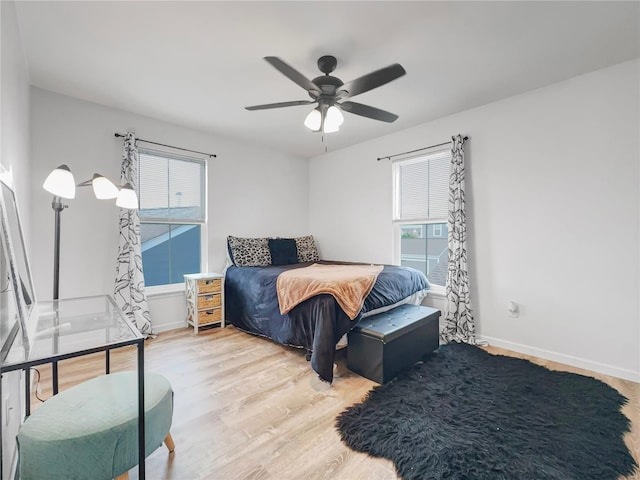 bedroom with a ceiling fan, baseboards, and wood finished floors
