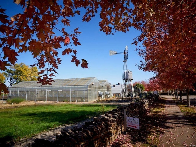 surrounding community with an outdoor structure, a yard, and a greenhouse