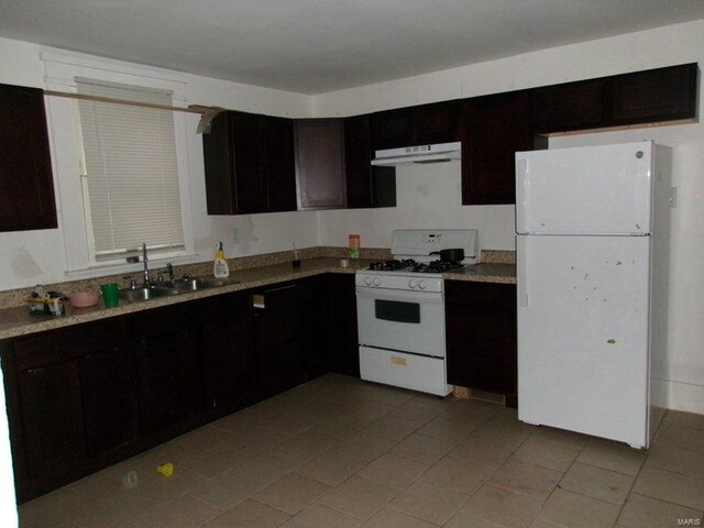 kitchen with a sink, light tile patterned floors, light countertops, under cabinet range hood, and white appliances