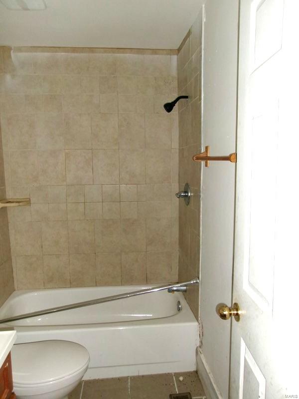 bathroom with vanity, tile patterned floors, toilet, and shower / washtub combination