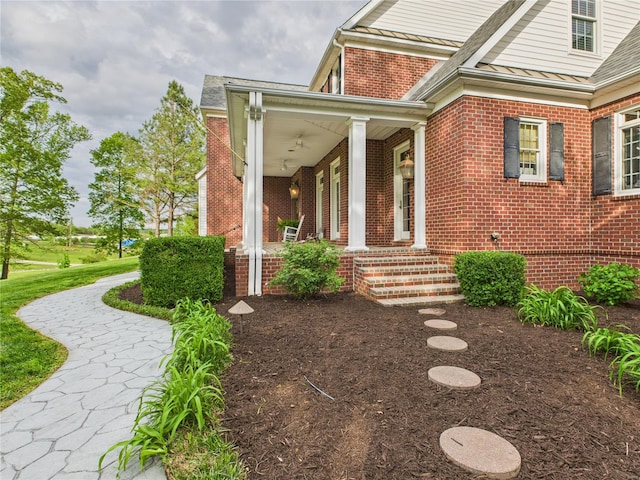 entrance to property with brick siding, roof with shingles, and a porch