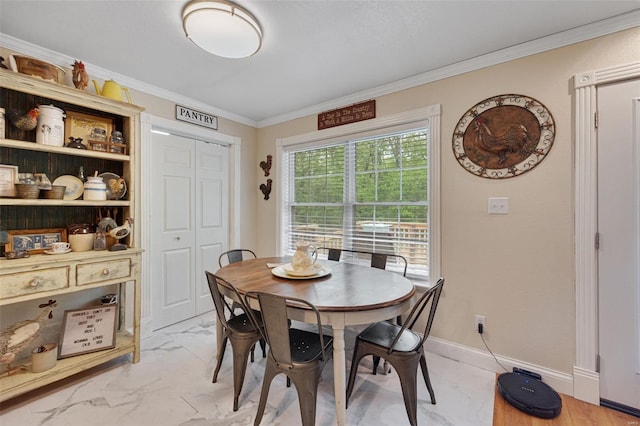 dining room featuring ornamental molding and marble finish floor