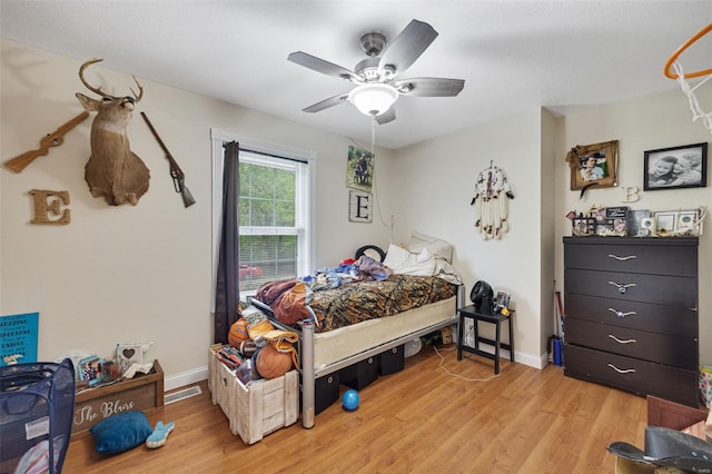 bedroom featuring light wood-style floors, baseboards, a ceiling fan, and visible vents
