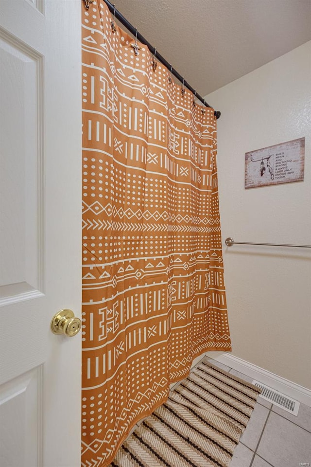 bathroom with tile patterned floors, visible vents, and baseboards