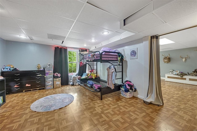 bedroom with baseboards and a paneled ceiling