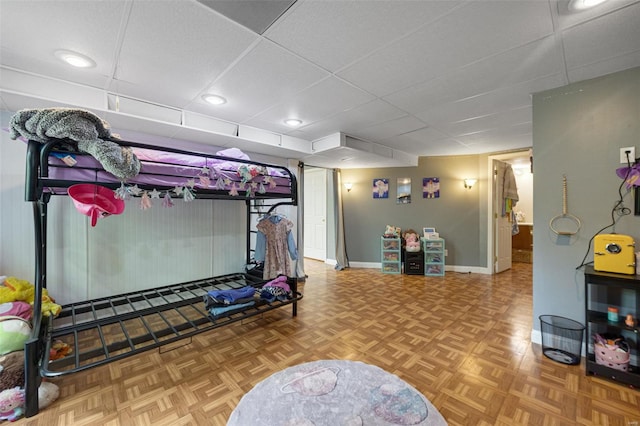bedroom with baseboards and a paneled ceiling