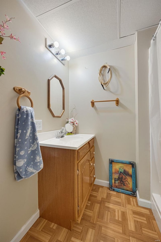 full bath featuring a textured ceiling, baseboards, curtained shower, and vanity