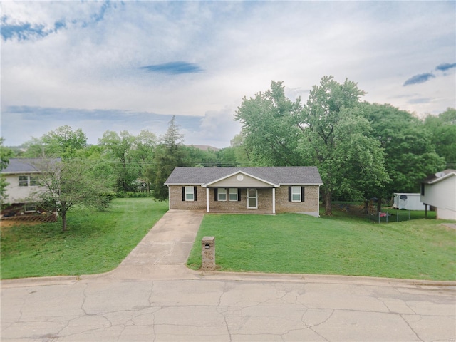 view of front facade featuring concrete driveway, brick siding, and a front lawn