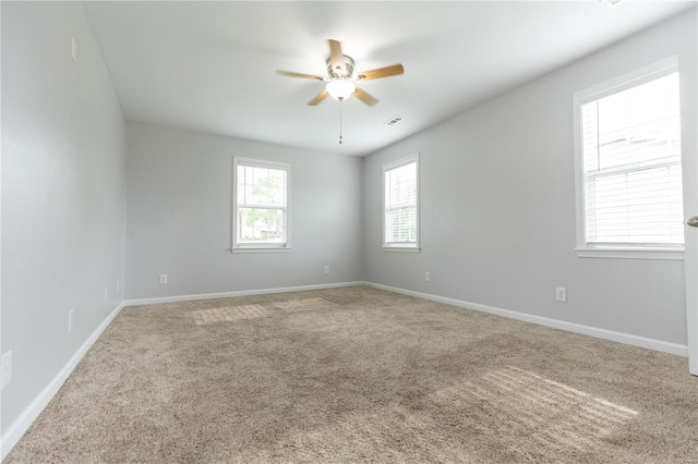 unfurnished room featuring carpet floors, ceiling fan, visible vents, and baseboards