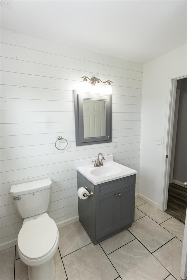 bathroom with vanity, tile patterned floors, baseboards, and toilet