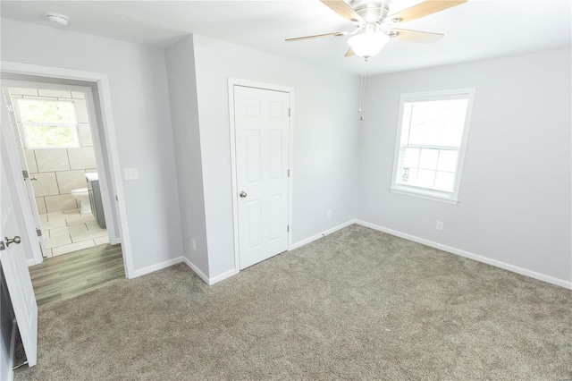 unfurnished bedroom with baseboards, carpet flooring, and a ceiling fan