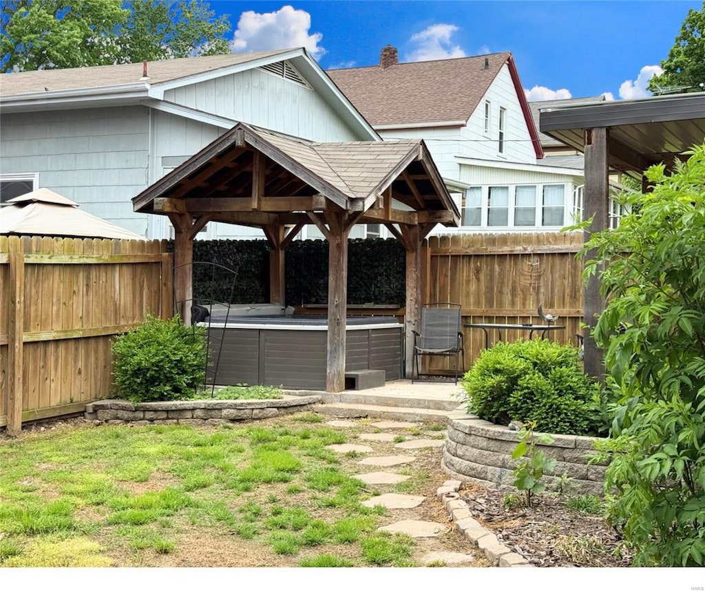 view of yard with a jacuzzi, fence, a gazebo, and central AC