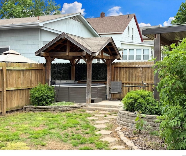 view of yard with a jacuzzi, fence, a gazebo, and central AC