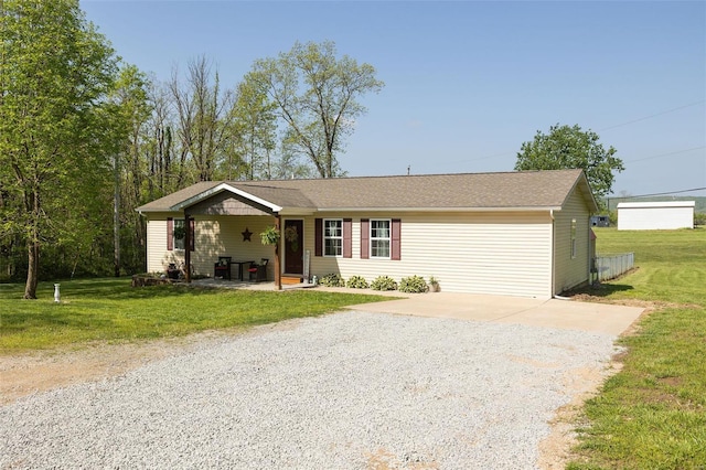 single story home featuring covered porch, a front lawn, and gravel driveway