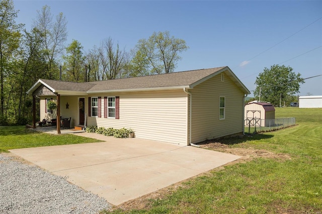ranch-style house with a porch, a shed, an outbuilding, and a front yard