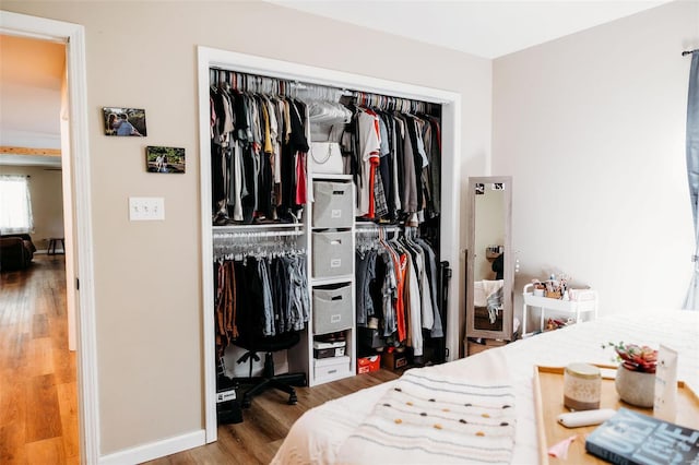 bedroom featuring baseboards, a closet, and wood finished floors